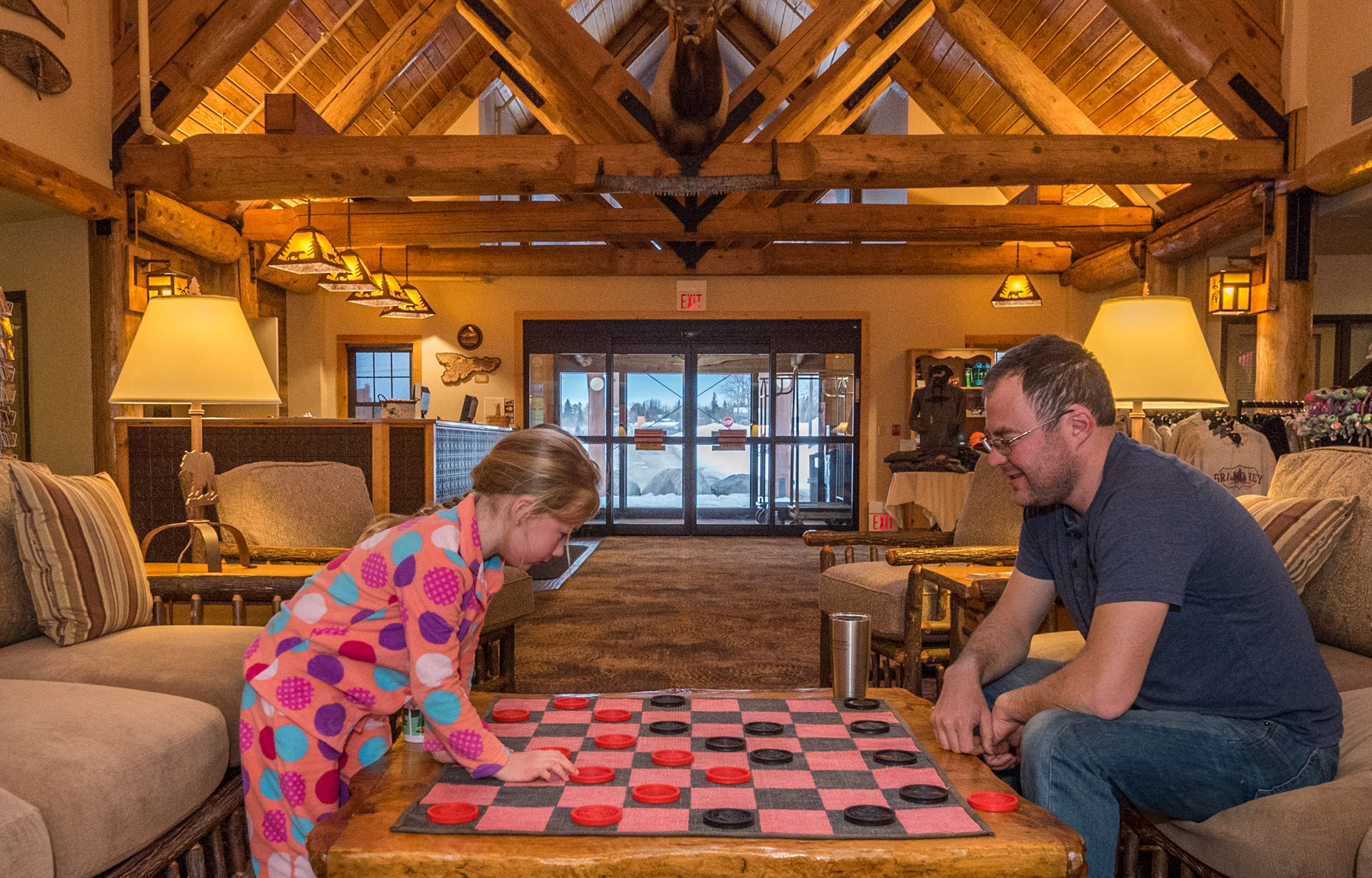 Father and daughter playing giant checkers in Grand Ely Lodge lobby