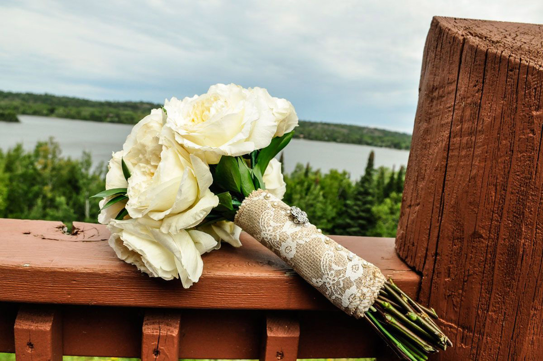 Bouquet of white roses laying atop Grand Ely Lodge balcony rail
